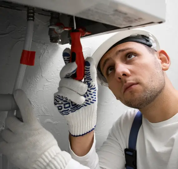 2149334225 Plumber fitting a modern boiler in a utility room, showcasing boiler installation service in London by We Fix Plumbing London.