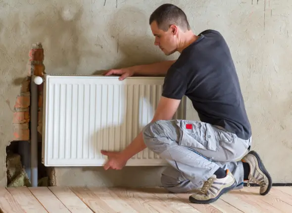 Professional plumber inspecting and maintaining central heating system in a London residence.