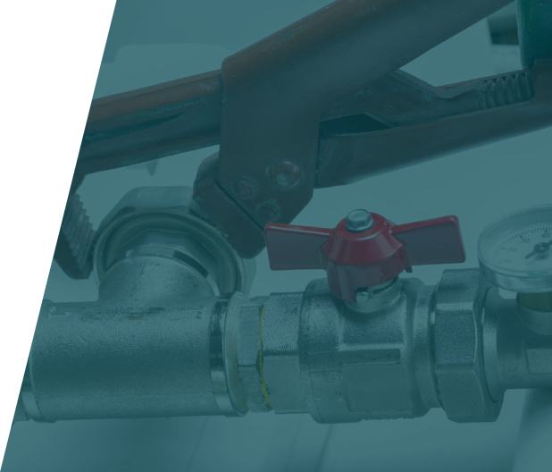 Close-up of plumbing tools and a red valve on a metal pipe, indicating professional plumbing repair work.