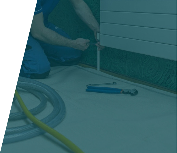 Plumber using a power flush machine to clean a heating system, representing power flushes service in London by We Fix Plumbing London.