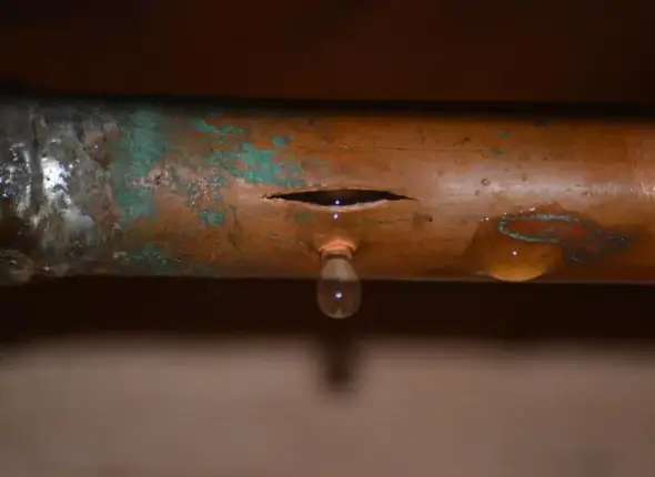 featured-image-burst-pipe.jpeg (1) Plumber repairing a burst pipe with significant water leakage, representing burst pipe repair service in London by We Fix Plumbing London.